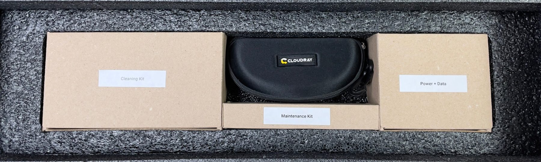 In-box accessories in the foam tray: cleaning kit, laser safety goggles, maintenance kit, and power and data cables